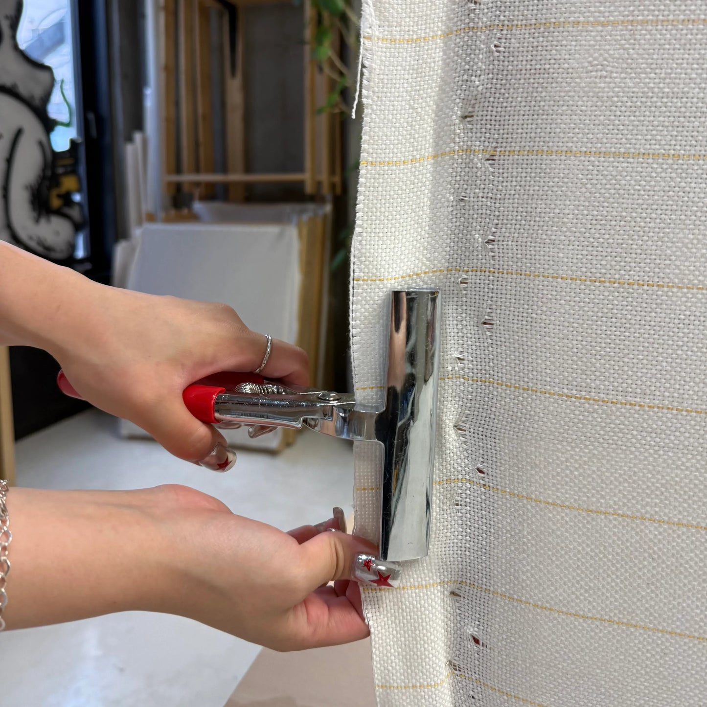 キャンバスキャッチャーで基布を引っ張っている様子