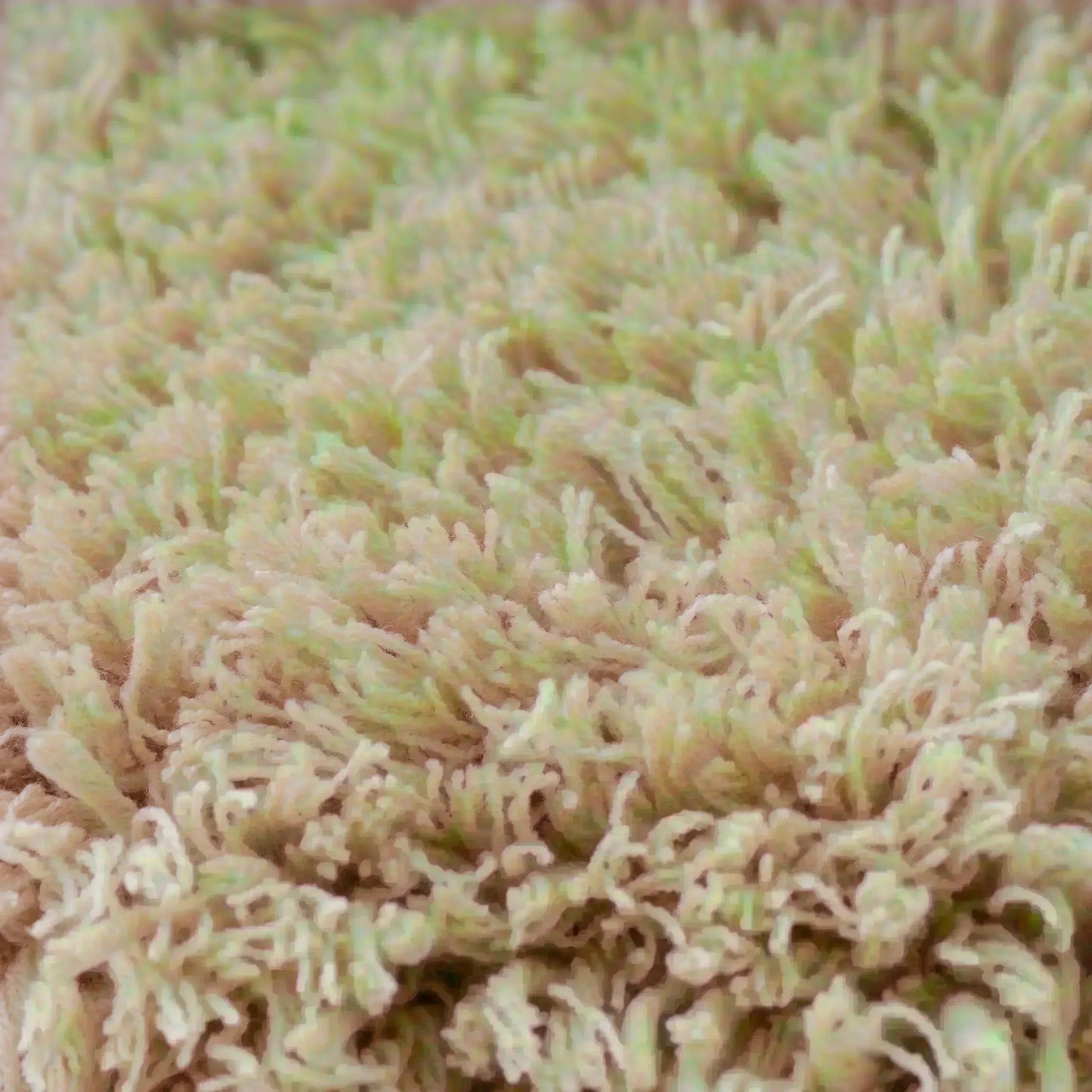 ベージュカラーのタフティングラグのクローズアップショット。柔らかい毛足が密集しており、ボリューム感のある仕上がり。繊維が均一で滑らかな触り心地を表現している