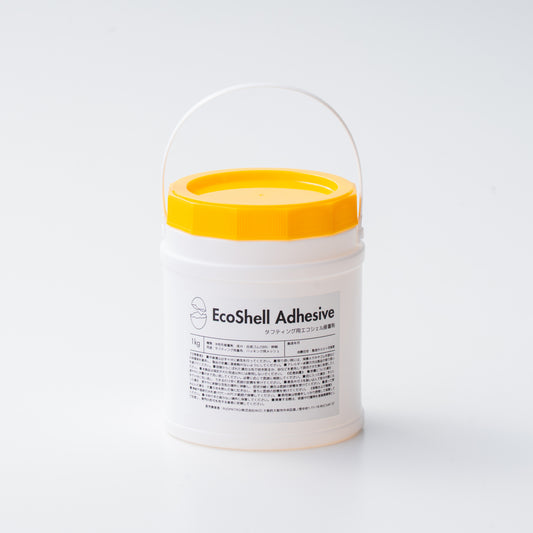 タフティング用接着剤 EcoShell Adhesive 1kg入り容器。白い円筒型ボトルに黄色のフタと持ち手付きで、使いやすい小容量タイプ。