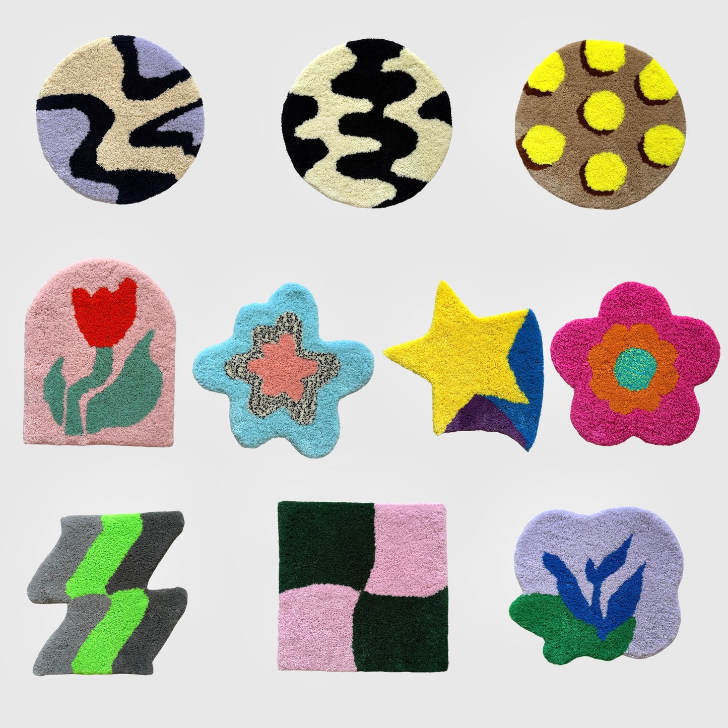 白い背景の上に並べられた9枚のタフティングラグ。円形、四角形、花型、星型など多様な形で、黄色の星、ピンクの花、赤いチューリップ柄など、カラフルなデザインが特徴的。