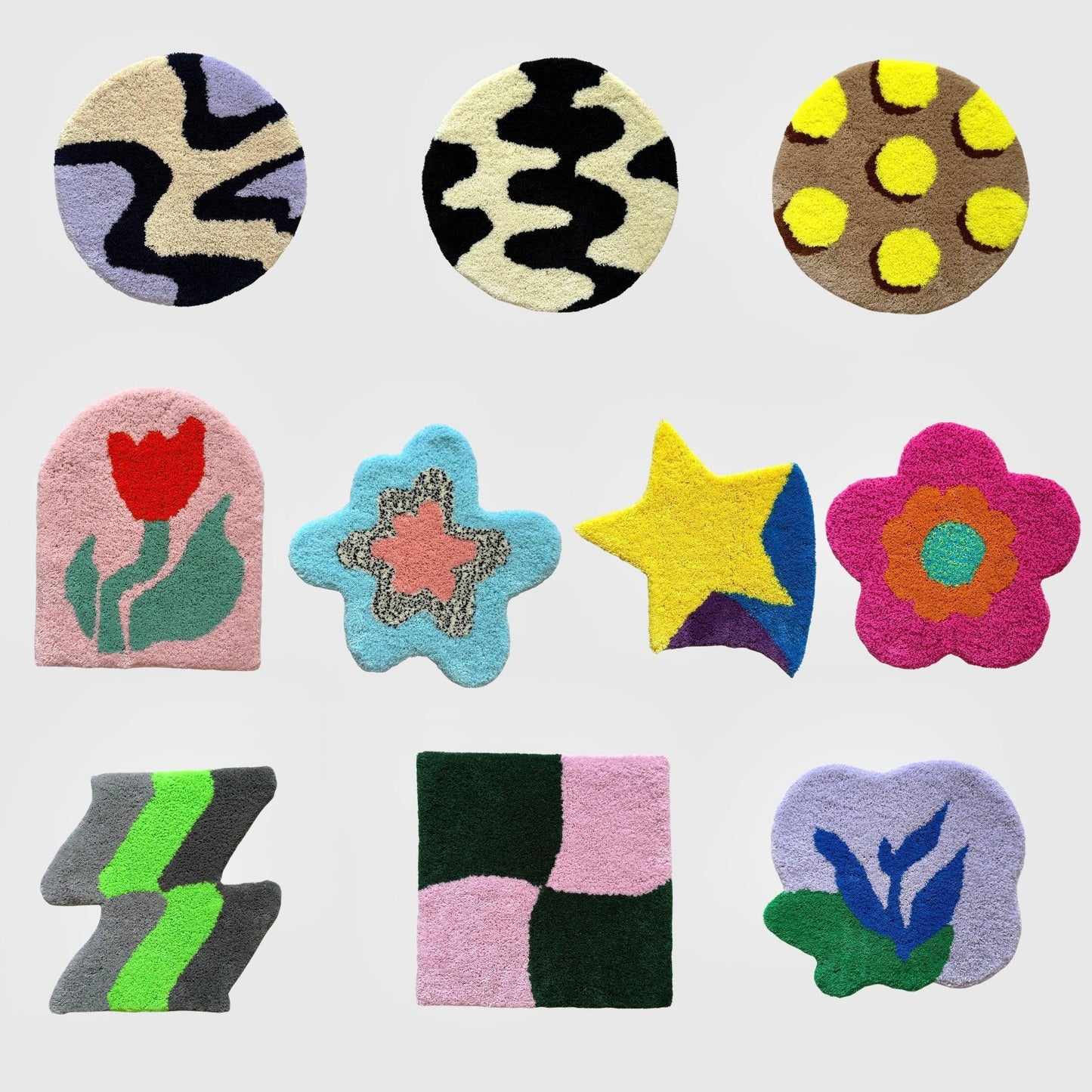 白い背景の上に並べられた9枚のタフティングラグ。円形、四角形、花型、星型など多様な形で、黄色の星、ピンクの花、赤いチューリップ柄など、カラフルなデザインが特徴的。