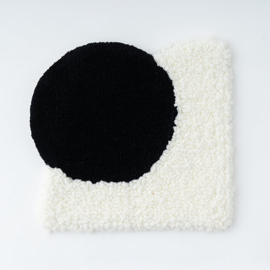 AK-DUOを使用して作成したラグのサンプル画像。丸と四角が合体しているでデザインのラグ。丸部分は黒い毛糸でカットパイル。四角部分は白の毛糸でループパイルになっている