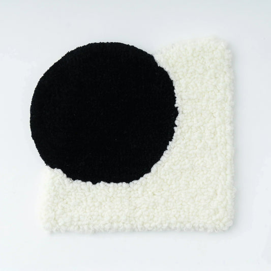 AK-DUOを使用して作成したラグのサンプル画像。丸と四角が合体しているでデザインのラグ。丸部分は黒い毛糸でカットパイル。四角部分は白の毛糸でループパイルになっている