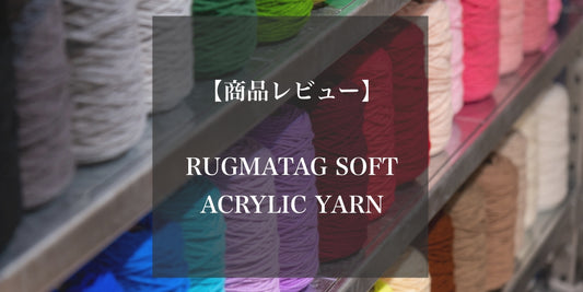 RUGMATAGのソフトアクリル毛糸の商品レビューを紹介する画像。背景にはカラフルな毛糸のコーンが棚に並んでおり、中央には『【商品レビュー】RUGMATAG SOFT ACRYLIC YARN』と書かれたテキストが配置されている。