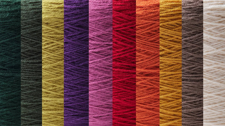ピンクベージュから濃いブラウン、オレンジやイエローまで、収穫をイメージした暖色系のウール毛糸が横一列に並んだ色見本。