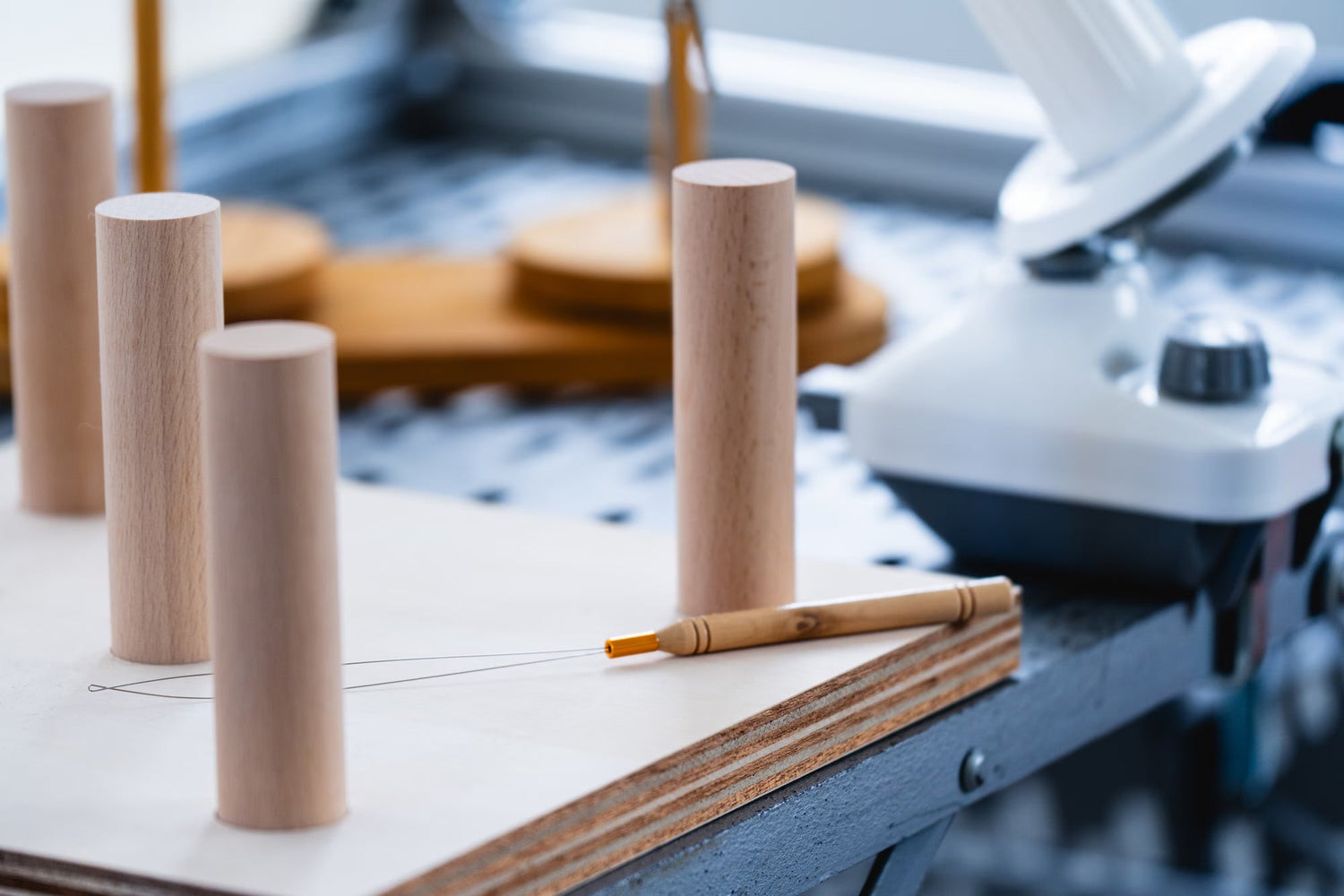木製の糸たてとタフティング用ツールが組み立てられた作業場の一部