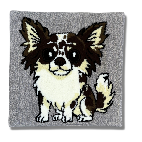 大きな耳と丸い目を持つチワワを描いたタフティングラグ。グレーの背景に、白と茶色の毛並みが表現されている。