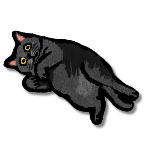 黒い毛並みと黄色い瞳が特徴の猫を描いたタフティングラグ。横たわる姿で、丸い目が印象的。