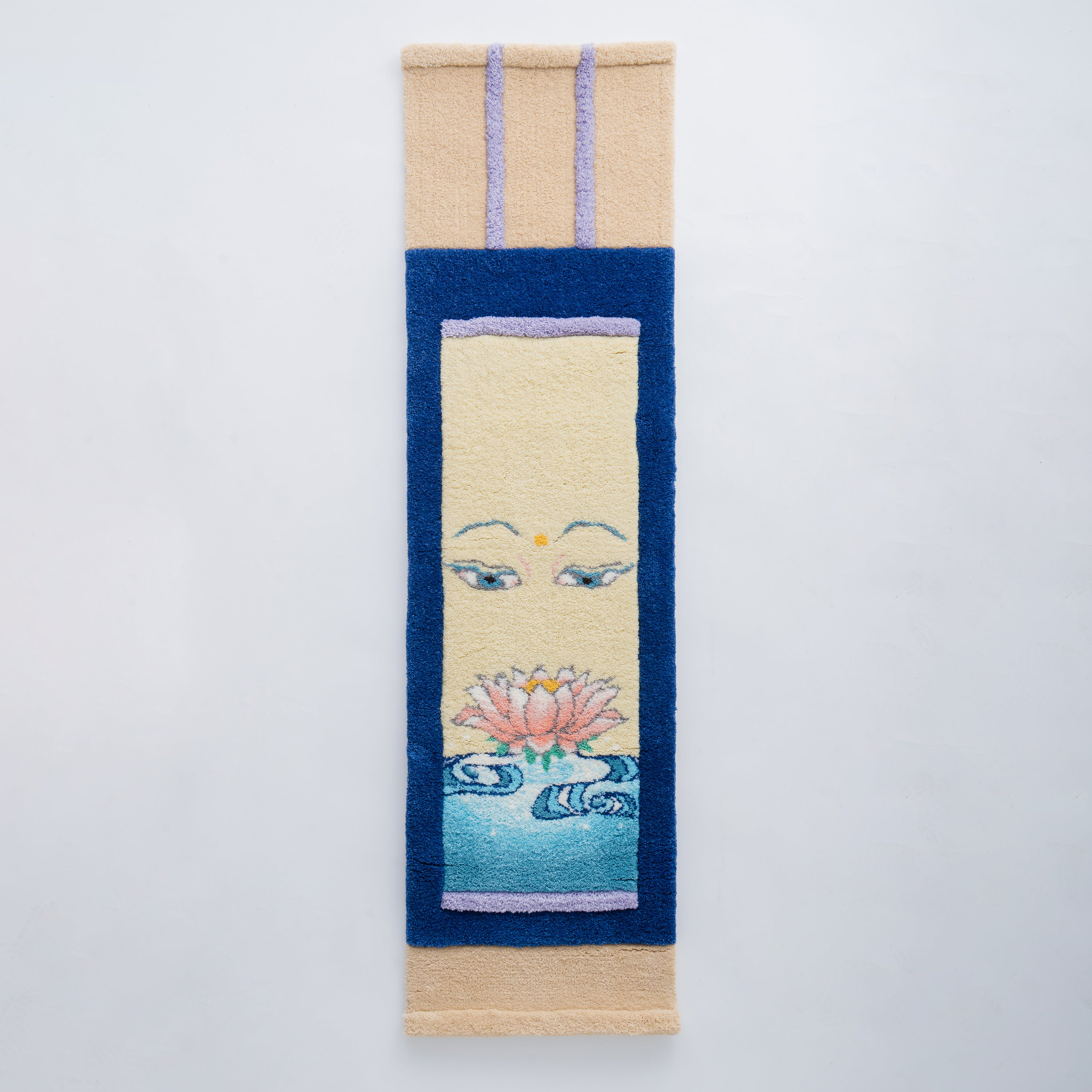 掛軸を現代的に再構築した縦長のタフティングアート。柔らかな表情の目元と蓮の花、水の波紋が毛糸で丁寧に描かれた和風アートラグ。RUGMATAGによる伝統×タフティングの融合作品