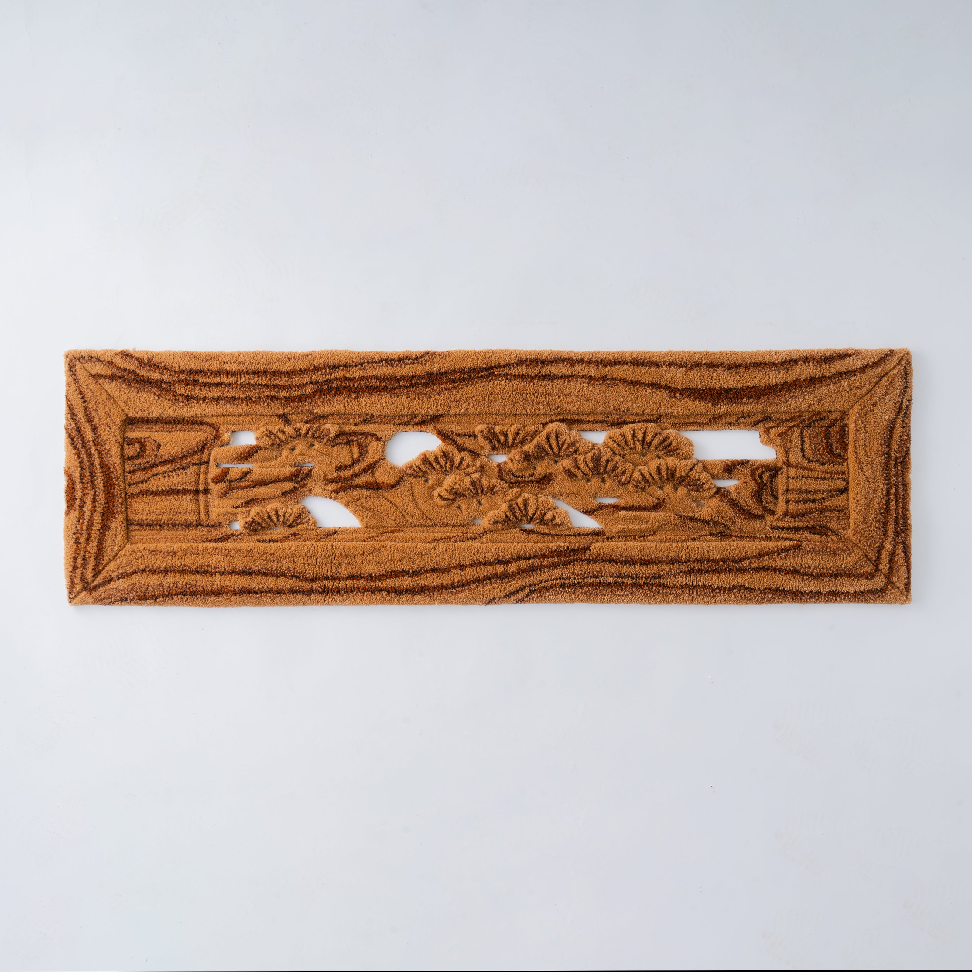 木目と松の彫刻をモチーフにした欄間風タフティングラグ。ブラウン系の毛糸で木材の彫りを立体的に再現し、和室にも合うアートピースに仕上げた作品。RUGMATAGの高度なカービング技術が特徴