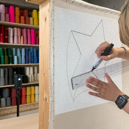 基布に星型の図案を定規とペンで下書きしている。