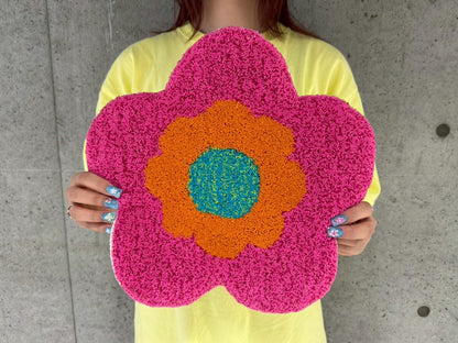 人物が手に持った花型のタフティングラグ。チェア&アートラグコース タフティングワークショップ 大阪北堀江