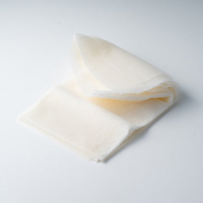 ラグ裏面の仕上げに使用する、白色のバッキングメッシュ