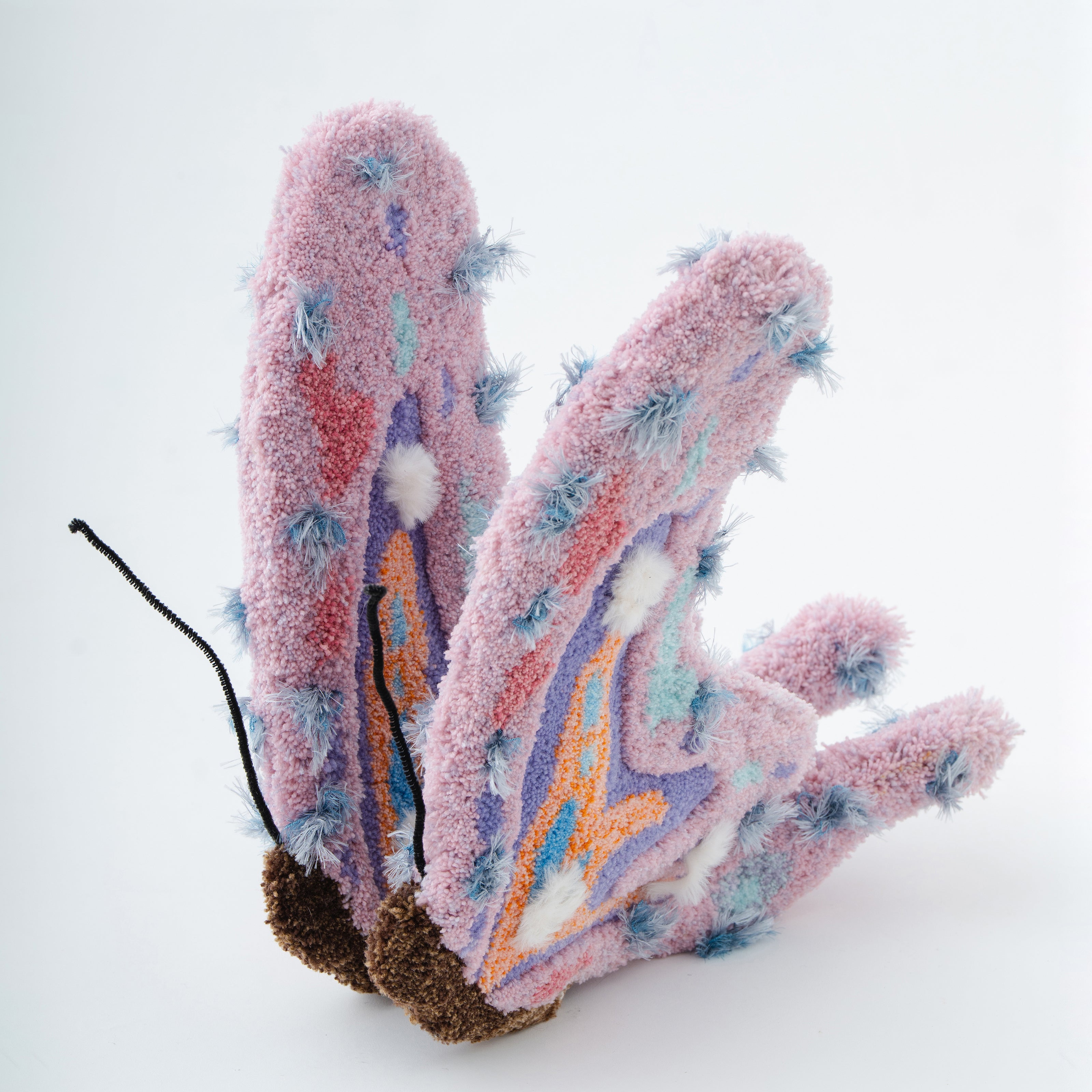 ピンクとパープルを基調とした蝶を立体的に造形したタフティングオブジェ。毛糸の長短や植毛位置でボリュームを出し、彫刻作品のように仕上げたアートピース。RUGMATAGの立体タフティング技法を活かした作品。