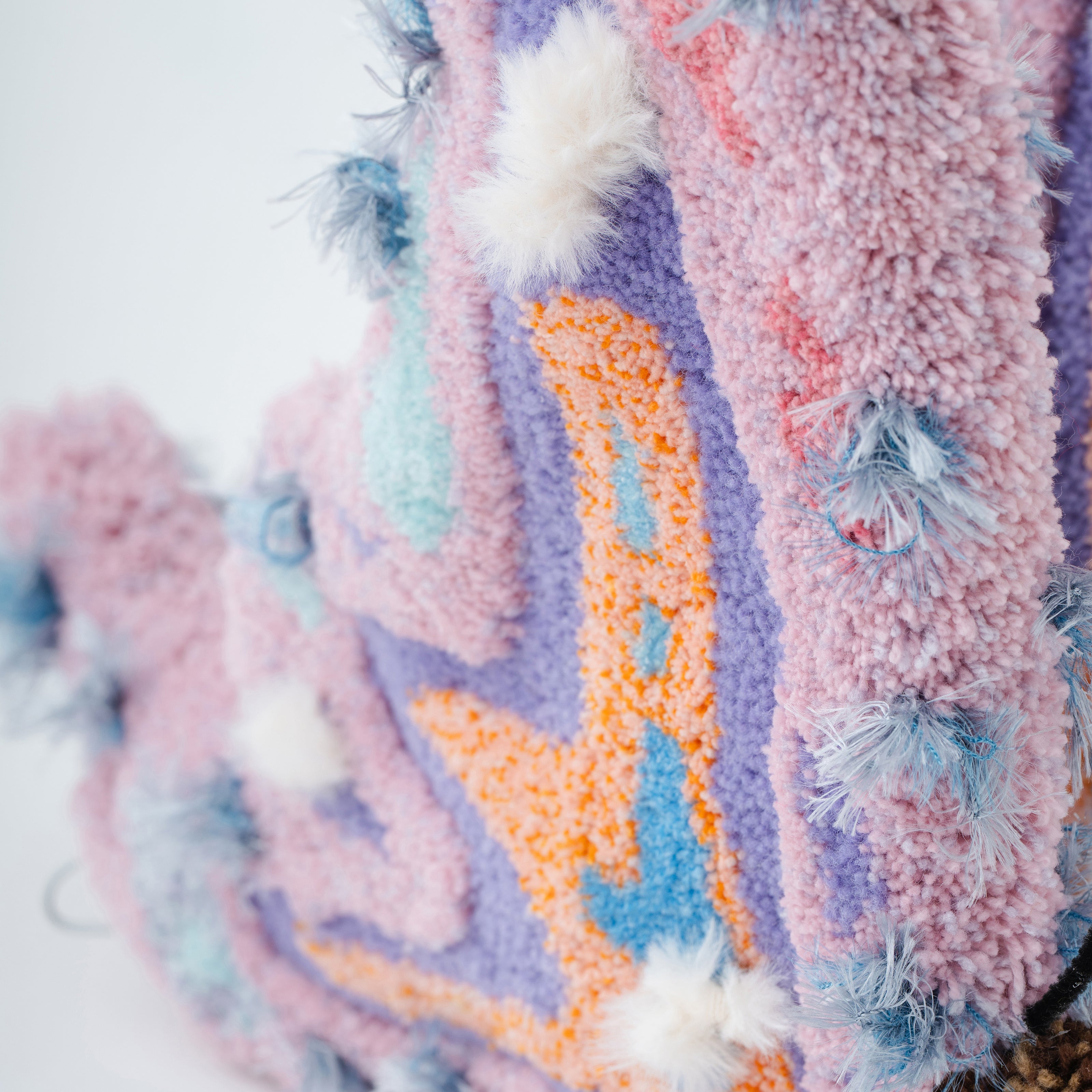 ピンク・ラベンダーを中心に構成された立体タフティング作品のディテール写真。フワフワとした毛足や色の重なり、立体的に盛り上がるパイルなど、繊細な質感が際立つクローズアップ。RUGMATAGの手仕事の精密さを映した一枚。